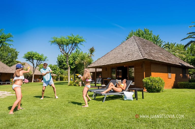 Familia jugando frente a su bungalow en el camping Montroig Tarragona