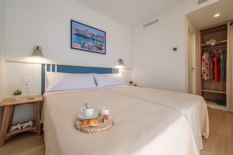 Dormitorio de matrimonio con armario y desayuno en apartamentos Ancora de Salou Tarragona