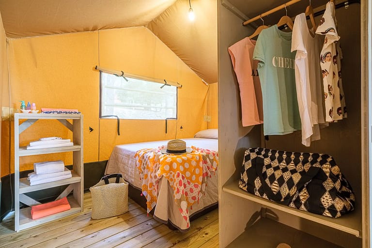 Dormitorio de matrimonio y armario con atrezzo en bungalow del camping Vendrell Platja