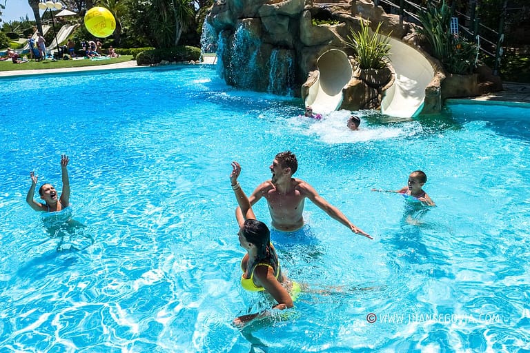 Familia jugando a la pelota en la piscina del camping Montroig Tarragona