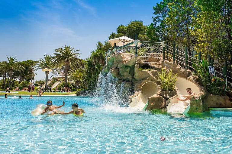 Familia jugando en el tobogan de la piscina del camping Montroig Tarragona