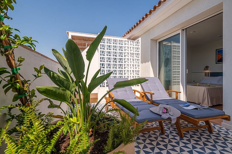 Solarium con plantas tumbonas y dormitorio en apartamentos Ancora de Salou Tarragona