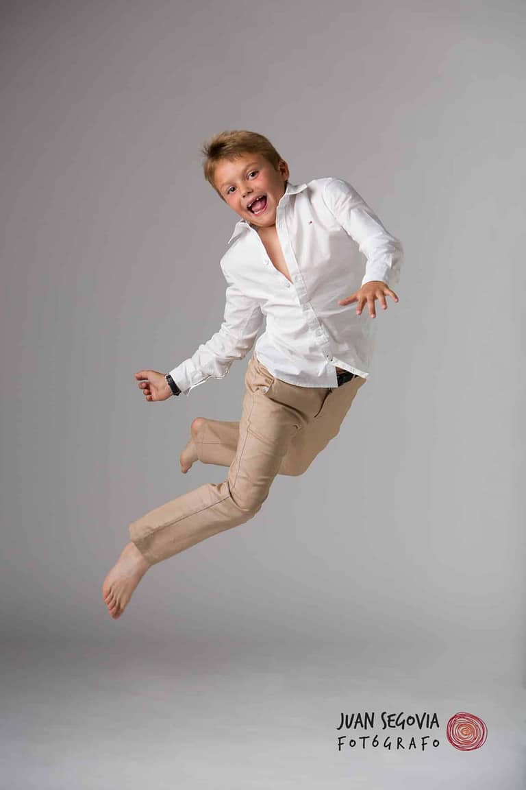 Divertida fotografía de un niño saltando, para su reportaje de comunión en estudio, por el fotógrafo Juan Segovia en Tarragona