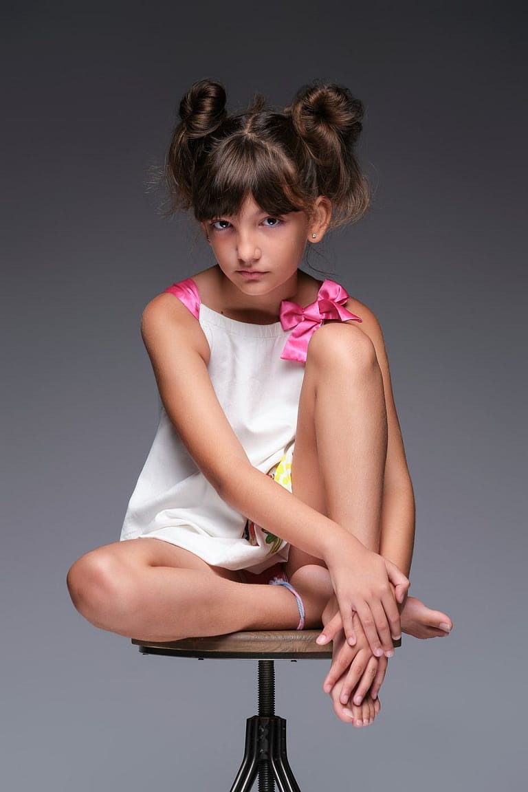 Retrato de una niña posando sentada en el estudio de Juan Segovia