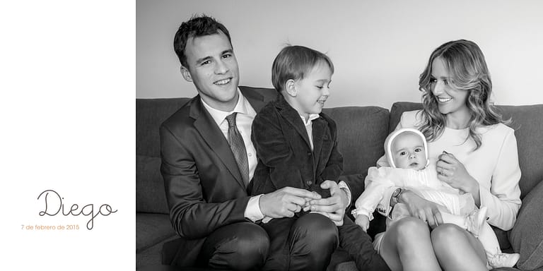 Fotografías de una familia posando con su bebé en el sofá de su casa para la celebración del bautizo del pequeño en Tarragona, por el fotógrafo Juan Segovia