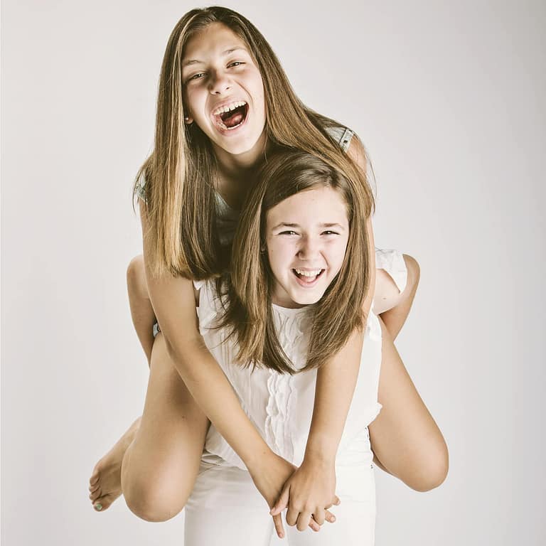 Dos hermanas sonriendo, Fotografía de familia en estudio. Juan Segovia, fotógrafo Tarragona