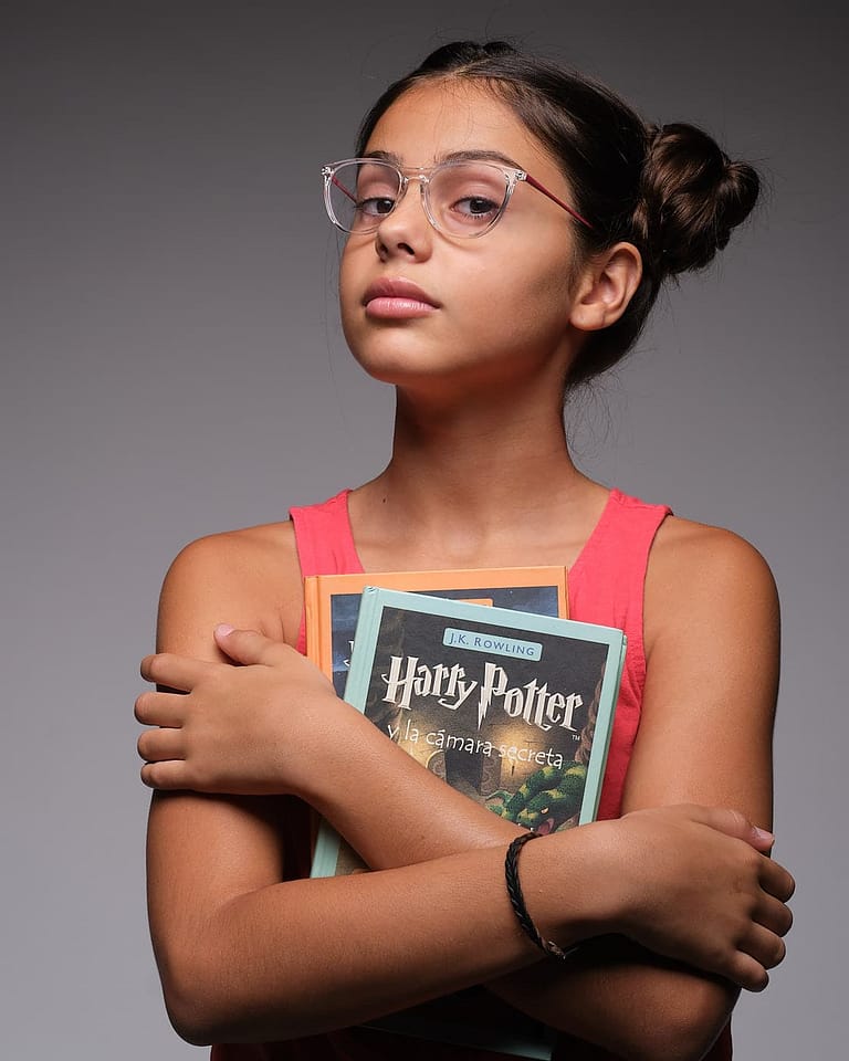 Fotografía en estudio para el book de la actriz Jasmine Serra con gafas abrazando unos libros