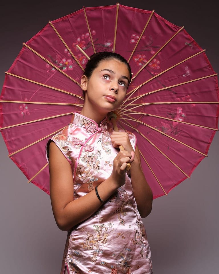 Fotografía en estudio para el book de la actriz Jasmine Serra, pensativa caracterizada de Chinita con kimono y sombrilla