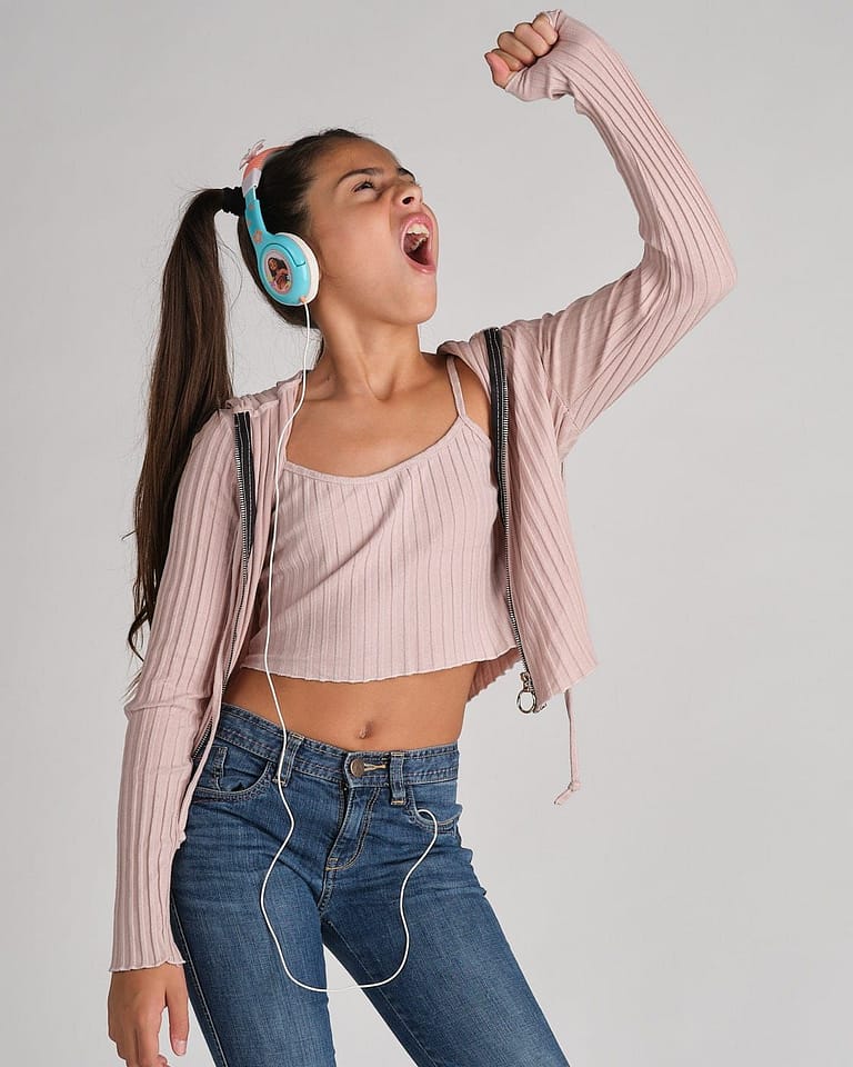 Fotografia para el book de la actriz Jasmine Serra cantando con coletas y auriculares en el cuello