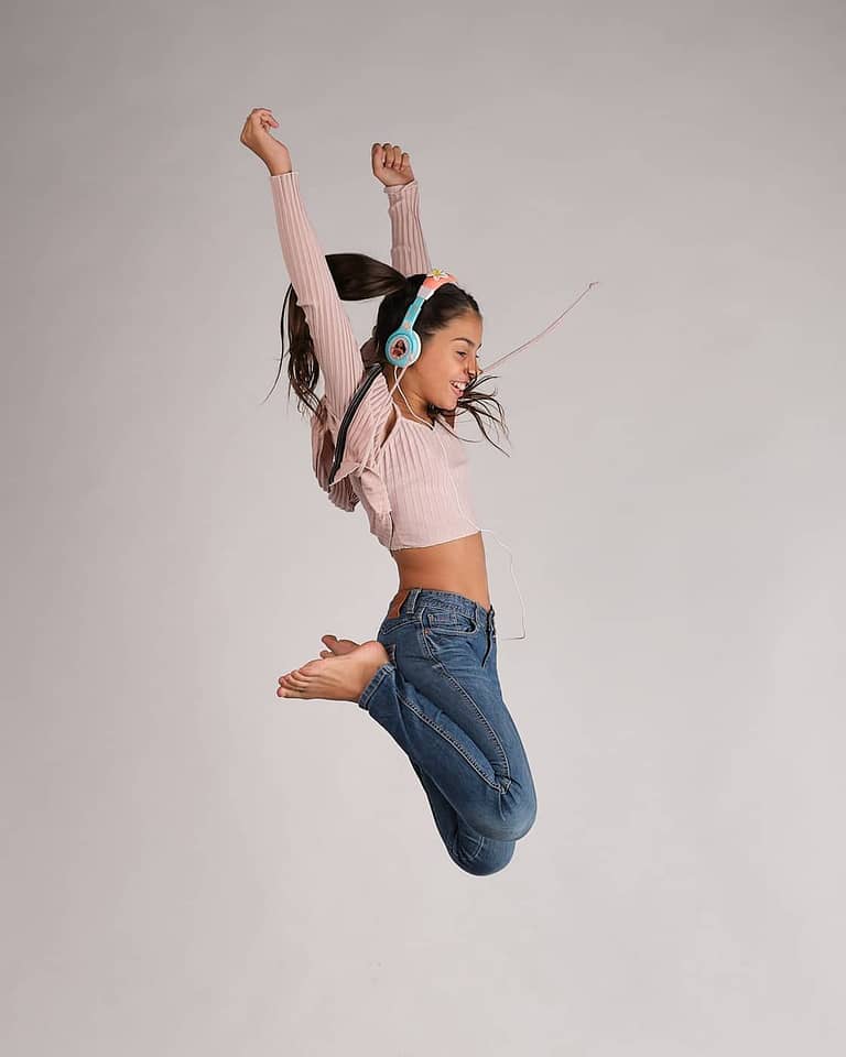 Fotografia para el book de la actriz Jasmine Serra saltando de perfil con coletas y auriculares